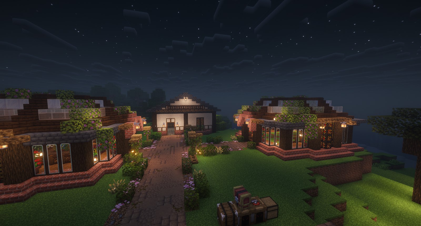 A landscaped Minecraft village with brick and timber houses, flowered roofs and glowing lanterns at night